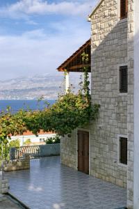 a stone house with a view of the ocean at Apartment Postira 3065a in Postira