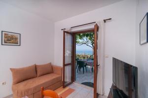 - un salon avec un canapé et une télévision dans l'établissement Apartment Postira 3065a, à Postira