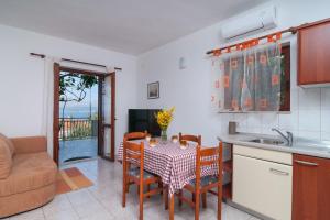 a kitchen and dining room with a table and chairs at Apartment Postira 3065a in Postira