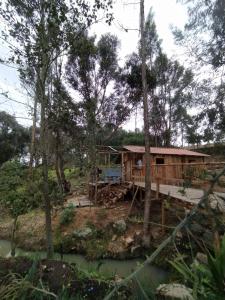 una cabaña en el bosque al lado de un río en La chala Guatavita, en Guatavita