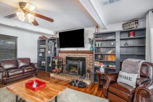 - un salon avec des fauteuils en cuir et une cheminée dans l'établissement Refuge Ranch Retreat Log Cabin Lake 53+ Acres, à Locust Grove