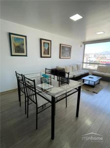 sala de estar con mesa y sofá en ItsaHome Apartments - Torre Seis, en Quito