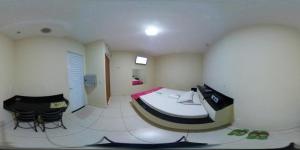 a room with a bed and two chairs in it at Motel& Hotel Apê Goiânia !!! in Goiânia