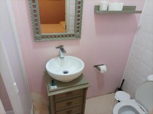 uma casa de banho com um lavatório, um espelho e um WC. em 2 Bedroom, 2 Bathroom With Terrasse - Palma Residence em Lisboa