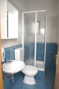 uma casa de banho com um WC, um lavatório e um chuveiro em Apartments and rooms by the sea Milna, Hvar - 3074 em Hvar