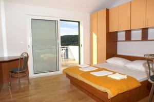 um quarto com uma cama e uma porta de vidro deslizante em Apartments and rooms by the sea Milna, Hvar - 3074 em Hvar