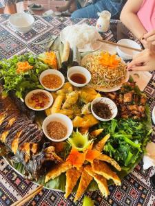 a table with a bunch of different types of food at Mai Chau Sunset Boutique Hotel in Mai Châu