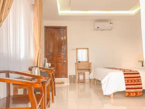 - une chambre avec un lit, une table et des chaises dans l'établissement Mai Chau Sunset Boutique Hotel, à Mai Châu