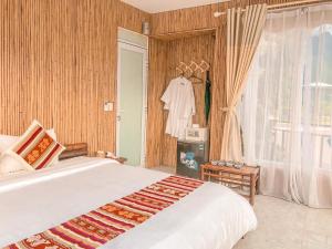 a bedroom with a large white bed and a window at Mai Chau Sunset Boutique Hotel in Mai Châu