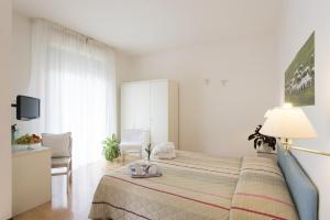 a bedroom with a bed with a lamp and a chair at Hotel Angiolino in Chianciano Terme