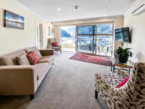 a living room with a couch and a tv and a table at Two Bedroom Apartment on the water in Picton