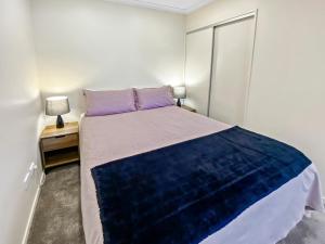 a bedroom with a large bed with a purple pillow at Two Bedroom Apartment on the water in Picton