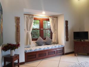 a bench in a room with a window at Beautiful Villa Indah in Seminyak