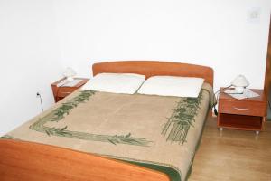 een slaapkamer met een bed met 2 nachtkastjes bij Apartment Mandre 3084c in Kolan