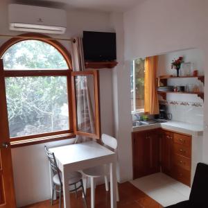 a small kitchen with a table and a window at The Finch House (La Casa del Pinzón) in Puerto Ayora