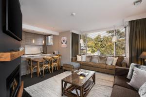 a living room with a couch and a table at Silver Run Thredbo in Thredbo