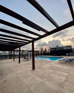 d'une terrasse avec une piscine et des bancs. dans l'établissement FLAT MARINAS PRAIA HOTEL, à João Pessoa