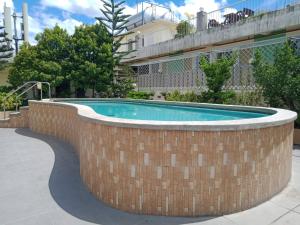 eine Backsteinmauer um einen Pool herum in der Unterkunft Six21 FAMILY UNIT with WIFI FREE! in Antipolo