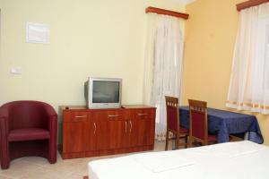 a room with a tv and a table and chairs at Double Room Rogoznica 3097a in Rogoznica