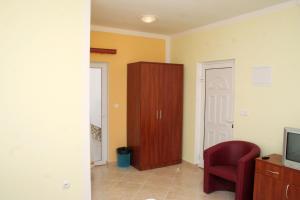 a living room with a red chair and a cabinet at Double Room Rogoznica 3097a in Rogoznica