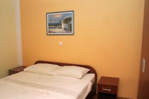 1 dormitorio con 1 cama y una foto en la pared en Apartment Rogoznica 3097a, en Rogoznica