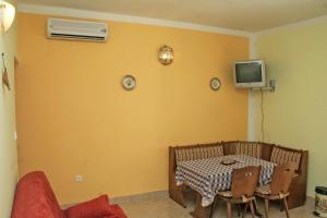 Habitación con mesa y TV en la pared. en Apartment Rogoznica 3097a, en Rogoznica