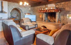 uma sala de estar com uma lareira de pedra com cadeiras e uma mesa em 4 Bedroom Nice Home In Buzet em Buzet