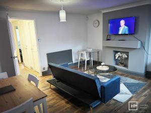 a living room with a couch and a tv at Enfield House - Beautiful 2 Bed - Good Transport Free Parking in Enfield Lock