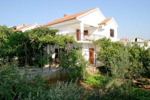 a white house with trees in front of it at Apartments with a parking space Businci, Ciovo - 4667 in Trogir