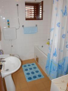 a bathroom with a toilet sink and a shower curtain at Apartments with a parking space Businci, Ciovo - 4667 in Trogir