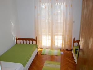 a bedroom with a bed and a window with curtains at Apartments with a parking space Businci, Ciovo - 4667 in Trogir
