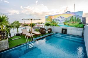 a swimming pool on the roof of a building with a painting at Quang Vinh Apartment and Hotel Hoi An in Hoi An