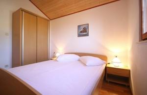 sypialnia z białym łóżkiem z 2 poduszkami w obiekcie Holiday house with a parking space Bol, Brac - 4661 w Bol