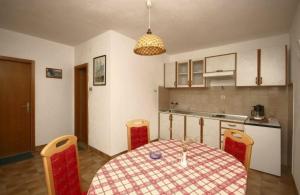 a kitchen with a table and chairs in a room at Apartments with a parking space Bol, Brac - 4659 in Bol