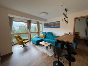 斯特爾布斯凱普萊索的住宿－Apartmán s výhľadom na štíty Ovruč 312，客厅配有蓝色的沙发和桌子