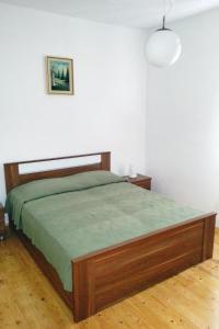 1 dormitorio con 1 cama con manta verde en Apartments by the sea Bol, Brac - 4657 en Bol