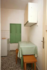 a kitchen with a table and a green cabinet at Apartments by the sea Bol, Brac - 4657 in Bol