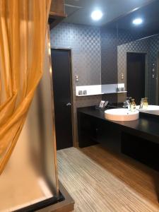 baño con 2 lavabos y espejo grande en ホテルハンズ en Ginan