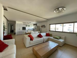 a living room with a white couch and red pillows at Beautiful 2-bedroom condo in the heart of Tel Aviv in Tel Aviv