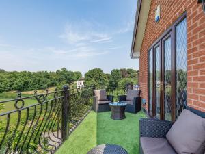 a balcony with chairs and a fence and grass at Freshwinds in Market Drayton