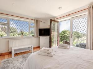a bedroom with a large white bed and windows at Freshwinds in Market Drayton