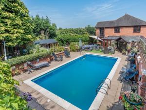 an overhead view of a swimming pool in front of a house at Freshwinds in Market Drayton