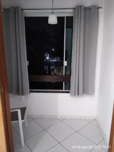 Cette chambre dispose d'une fenêtre avec une chaise et une table. dans l'établissement Cantinho Bonsai, à Rio de Janeiro