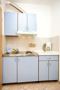 a kitchen with white cabinets and a sink at Apartments with a parking space Duce, Omis - 4650 in Duće