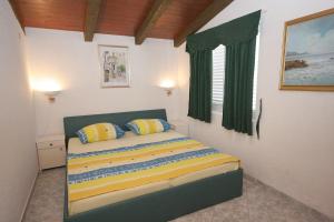Schlafzimmer mit einem Bett mit gelben und blauen Kissen in der Unterkunft Apartments by the sea Cove Jagodna - Brusje, Hvar - 4619 in Brusje