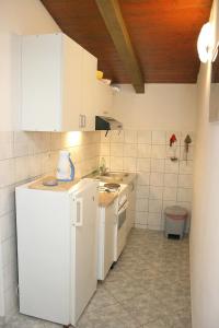 a kitchen with white cabinets and a white refrigerator at Apartments by the sea Cove Jagodna - Brusje, Hvar - 4619 in Brusje