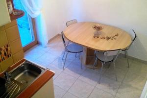 uma mesa e cadeiras numa cozinha com um lavatório em Apartments with a parking space Bol, Brac - 4658 em Bol
