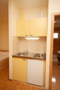 una cocina con armarios blancos y fregadero en Studio Omis 4654b, en Omiš