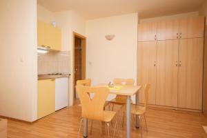 cocina y comedor con mesa y sillas en Studio Omis 4654b, en Omiš
