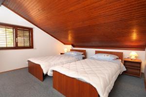 2 letti in una camera con soffitto in legno di Apartments with a parking space Dubrovnik - 4673 a Dubrovnik